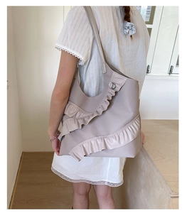 Detail view of the layered ruffle pleats and smooth texture of this ballet-style tote bag