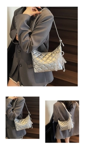 Macro shot of silver quilted faux leather shoulder bag with studs and pearl charm
