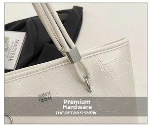 Détail du sac cabas blanc motif crocodile avec anneaux argentés et logo chic