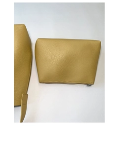 Dettaglio della pochette in pelle martellata giallo zenzero con zip in metallo argento