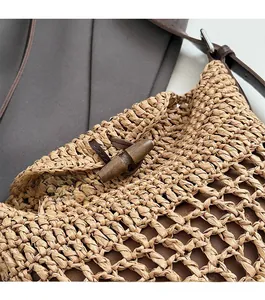 Detail of wooden toggle closure and leather strap on hand-woven straw shoulder bag