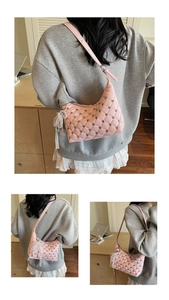 Detail of pink quilted bag with silver studs and lace pearl charm in indoor setting