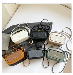 Flat lay of luxury mini crossbody box bags in six colors with gold twist locks