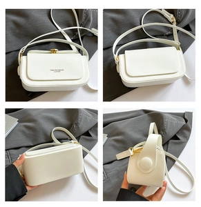 Detail view of white leather crossbody bag with gold twist lock and accordion side panels