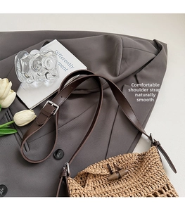 Detail of woven straw shoulder bag with leather strap and wooden button closure