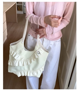 Detailed view of cream tote bag featuring elegant lace ruffles and layered bow design