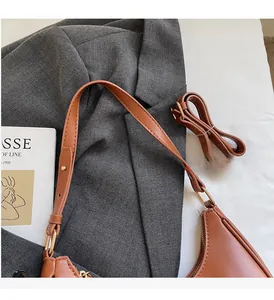Close-up of caramel PU leather handbag with golden hardware and adjustable strap detail