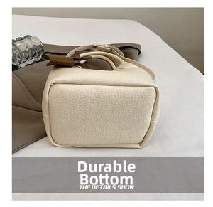 Vue détaillée du fond du sac en cuir beige texturé avec une finition grainée élégante