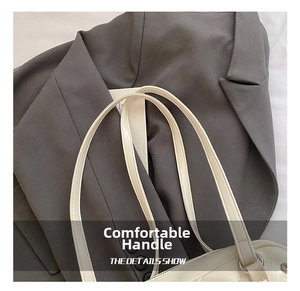 Detail view of quilted cream tote bag featuring comfortable slim leather double handles