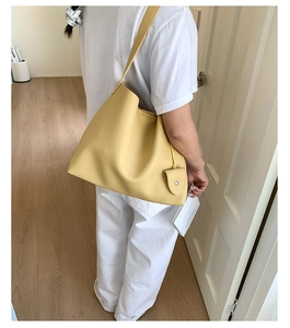 Dettaglio borsa tote gialla in pelle a grana con portamonete coordinato ed elegante