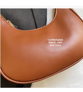 Macro shot of brown PU leather texture and golden metal zipper on the crescent hobo bag