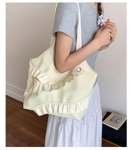 Detail of a creamy white large tote bag with tiered ruffles and lace ballet core aesthetic