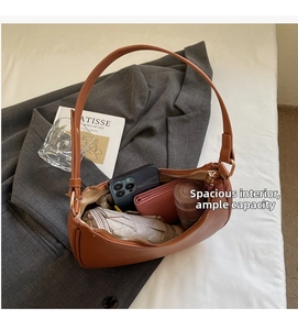 Interior view of brown leather half-moon bag showing large capacity for daily essentials