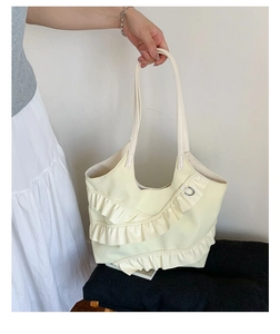 Close-up of the pleated lace and bow design on the cream yellow faux leather tote bag