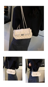 Detailed view of white quilted crossbody bag featuring gold chain and metal buckle