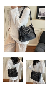 Detail of black washed denim tote bag showing wide shoulder strap and metal hardware