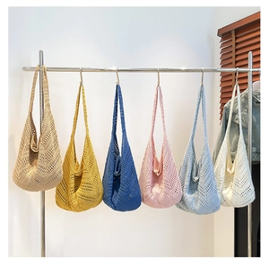 Detail of crochet tote bags in six colors hanging on a rack for summer beach style