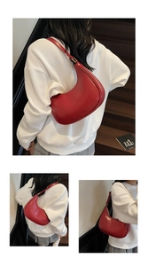 Detail of red crescent hobo bag made of smooth leather worn over the shoulder
