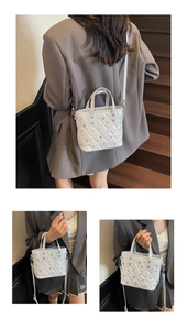 Detailed close-up of quilted pattern and metal stud accents on white crossbody bucket bag