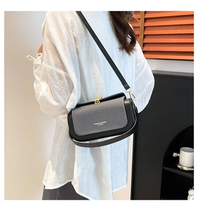 Detail of fashion crossbody bag with golden square lock and textured patchwork design
