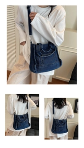Detail of dark blue denim tote bag with frayed edges and adjustable shoulder strap