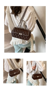 Detail of dark brown quilted crossbody bag with silver twist lock and chain strap detail
