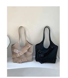 Detailed view of the layered ruffle texture and satin finish on black and beige tote bags