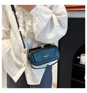 Detail of black leather crossbody bag with gold buckle and fashion text branding