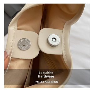 Detailed view of the magnetic metal clasp and textured lining of the cream shoulder bag