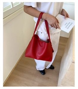 Dettaglio della borsa tote in pelle rossa con trama litchi e grande capacità interna