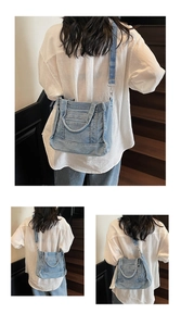 Detail of light blue denim tote bag with wide shoulder strap shown on a wooden staircase