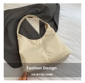 Detail of hobo shoulder bag featuring vertical center stitching and cream nylon fabric