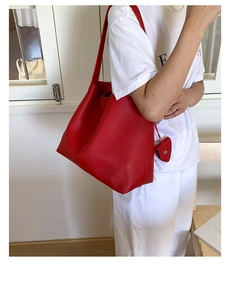 Dettaglio borsa tote rossa in pelle con grana litchi e ciondolo a cuore