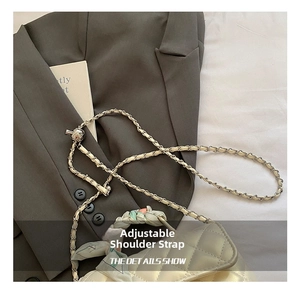 Detail of pearl white quilted crossbody bag with silk scarf handle and adjustable metal ball