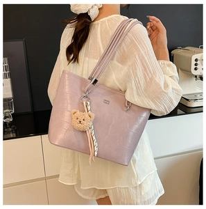 Détail du sac fourre-tout lilas motif crocodile avec breloque ours et logo argenté