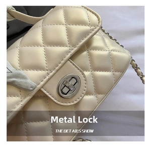 Detail of cream quilted handbag with silver swivel lock and decorative silk scarf wrap