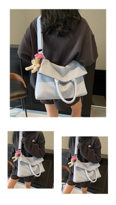 Detalle de bolso tote de cuero sintético azul claro con colgante de cachorro suave