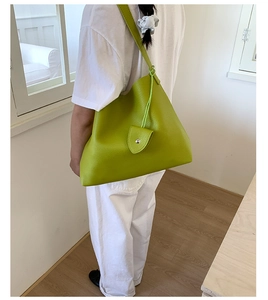 Dettaglio della borsa tote verde con trama litchi e mini pochette a triangolo inclusa