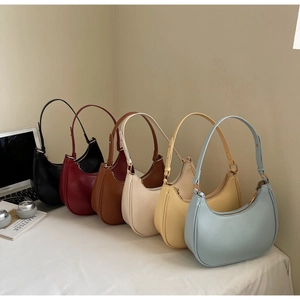 Minimalist half-moon underarm bags in six matte colors with adjustable shoulder straps