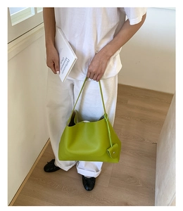 Borsa tote verde lime in pelle con piccolo portamonete abbinata a un outfit bianco