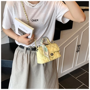 Detail of yellow quilted leather crossbody bag featuring floral silk scarf handle and gold chain
