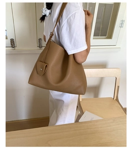 Dettaglio della borsa tote in pelle martellata color caramello con tracolla in stanza minimal