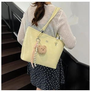 Détail du sac cabas jaune clair texture crocodile avec ours en peluche et foulard rayé