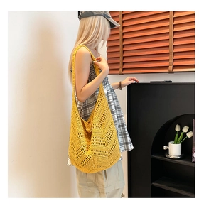 Close-up of bright yellow hand-woven hollow hobo bag with bohemian geometric patterns