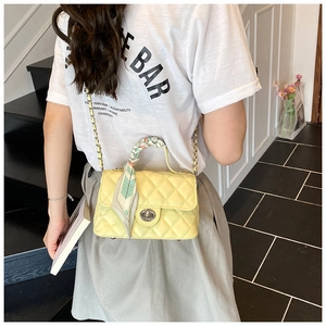 Yellow quilted crossbody bag with silk scarf handle on model's shoulder shown from behind