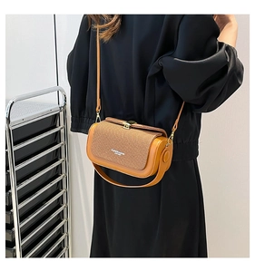 Brown vintage cylindrical crossbody bag with woven texture lid and elegant shoulder strap