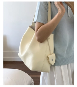 Dettaglio della borsa tote crema in pelle martellata con mini portamonete coordinato