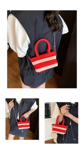 Detail of red and white striped woven mini tote bag with red handles and silver chain