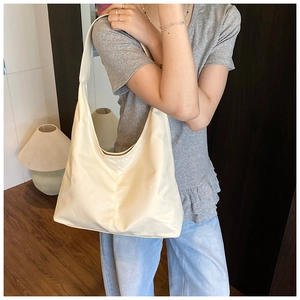 Side view of a creamy white large capacity hobo bag with wide strap and sleek stitching