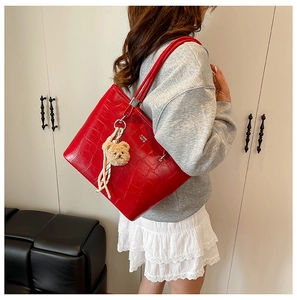 Détail du sac cabas rouge motif crocodile avec charm ourson et foulard imprimé